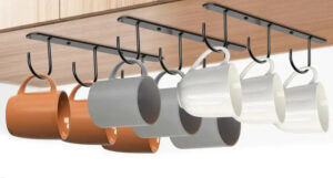 mugs hanging from hooks under a cupboard