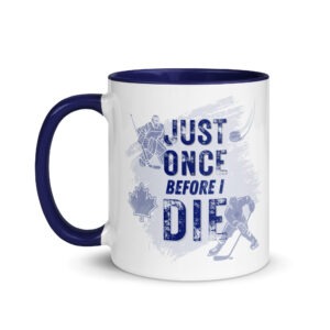 White ceramic coffee mug with a blue contrasting handle and interior, featuring a distressed hockey graphic and text reading "JUST ONCE BEFORE I DIE".