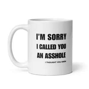 Funny sarcastic white ceramic coffee mug featuring bold black typography reading "I'M SORRY I CALLED YOU AN ASSHOLE" with smaller text below reading "I THOUGHT YOU KNEW" printed on the side.